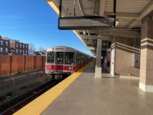 Mbta commuter rail train at elevated station platform at 68 Beale Apartments, Quincy, Massachusetts