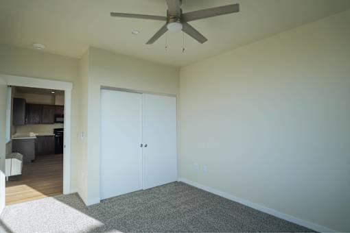 A room with a ceiling fan and a carpeted floor.