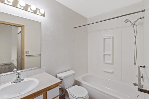 A white bathroom with a sink, toilet, and bathtub.