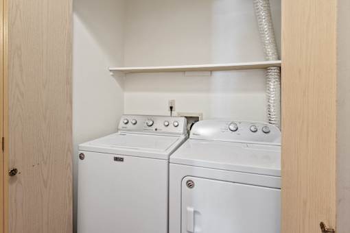 A white washing machine and dryer in a small laundry room.