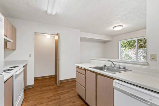 A kitchen with white appliances and wooden cabinets.