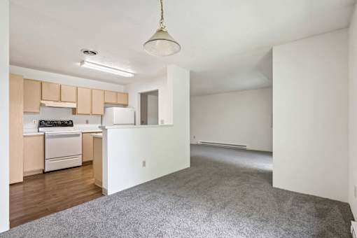 A kitchen with a white refrigerator and wooden cabinets.