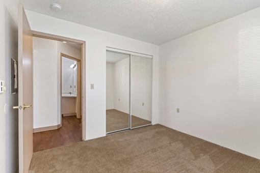A room with a carpeted floor and a mirror on the wall.