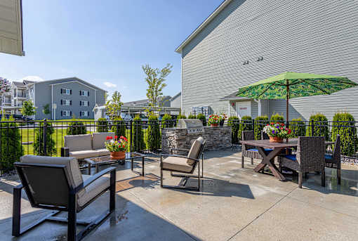 A patio with a table and chairs and an umbrella.