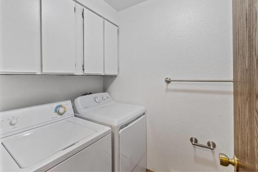 A small laundry room with a washer and dryer.