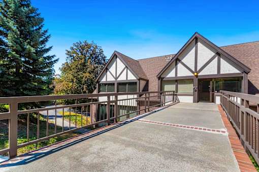 A house with a brown roof and white walls has a driveway leading to the front door.