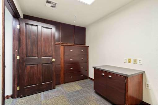 A room with a brown door and a brown cabinet.