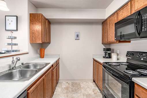 A kitchen with a black microwave above the stove.