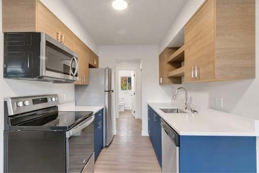 A kitchen with a black oven and blue cabinets.