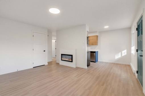 A spacious living room with a fireplace and hardwood floors.