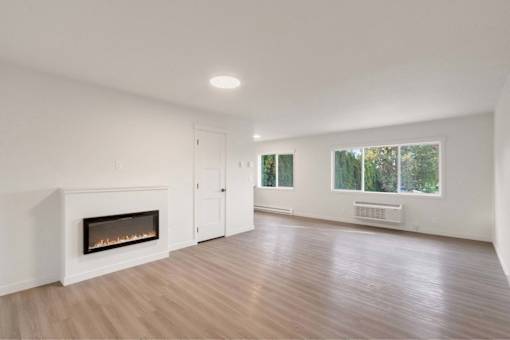 A room with a fireplace and wooden floors.
