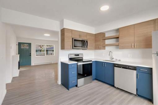 A kitchen with blue cabinets and a white fridge.