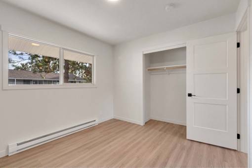 A room with a white door, a window, and a radiator.