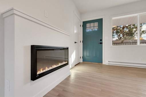 A room with a fireplace and a blue door.
