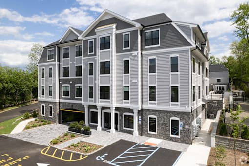 A large grey building with a parking lot in front.