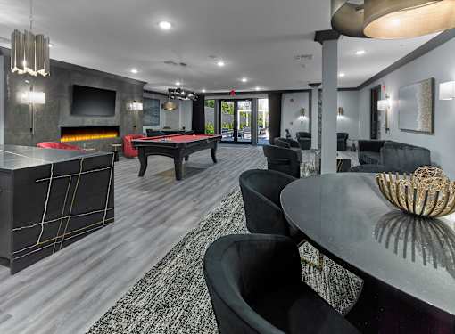 A modern living room with a pool table and a fireplace.
