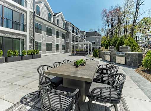 A patio with a table and chairs is surrounded by apartment buildings.