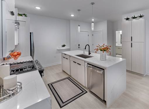 A modern kitchen with a white color scheme and stainless steel appliances.