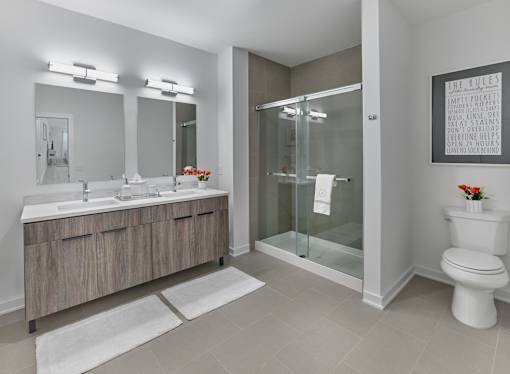 A bathroom with a toilet, sink, and mirror.