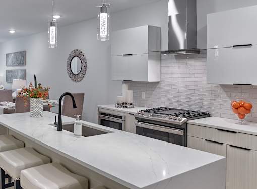 A modern kitchen with a white marble countertop and stainless steel appliances.