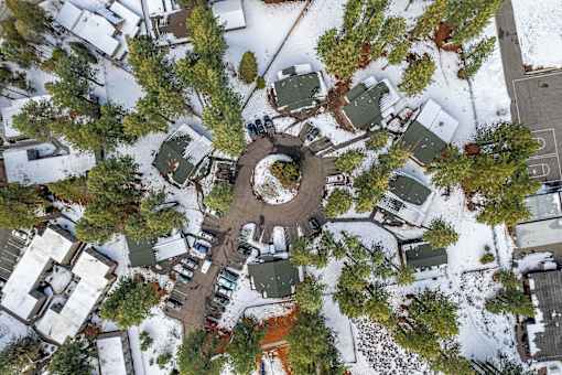 A bird's eye view of a snowy residential area with houses and trees.