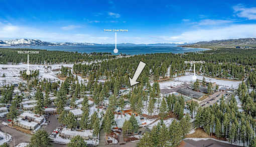 A snowy landscape with a lake and mountains in the background.