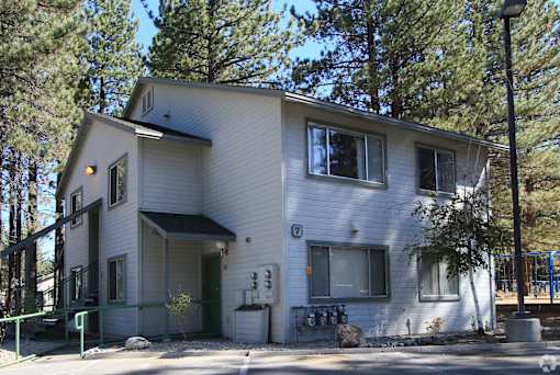 A two-story house with a white exterior and a green door.