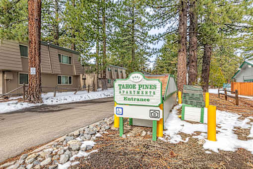 A sign for Tahoe Pines apartments stands in front of a building.
