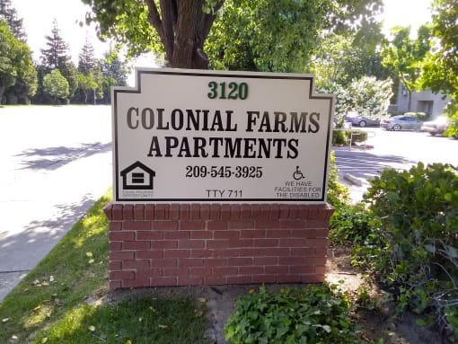 Colonial Farms Apartments - address sign with phone number 209-545-3925 and TTY 711