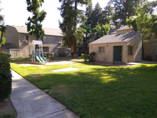 Colonial Farms Apartments - view of lawn and playground with apartment buildings in background