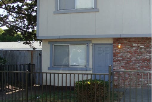 a house with a blue door and a red brick wall