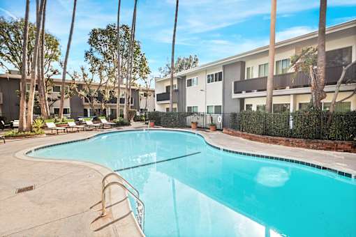 A swimming pool in front of a building with trees around it at Villa Vicente, Los Angeles, CA