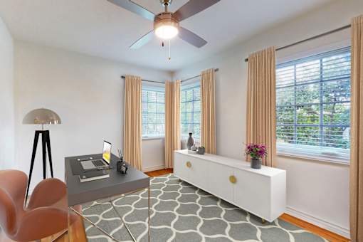 A room with a table, chairs, and a ceiling fan.