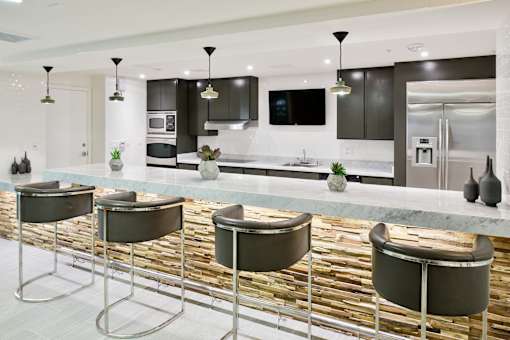 A modern kitchen with a bar area featuring four bar stools at Esprit Marina del Rey, 90292