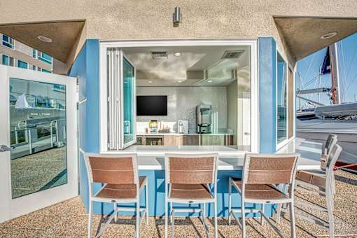 A dining table with chairs is set up outside a house.