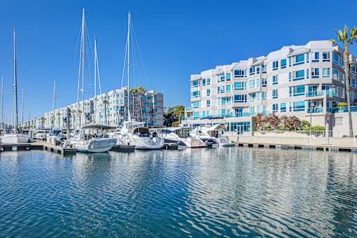 A marina with boats and yachts in front of a white building at Esprit Marina del Rey, 90292