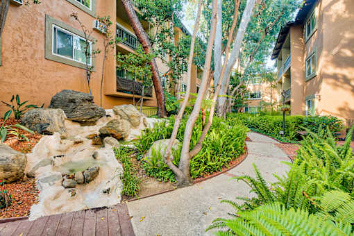 a walkway leading to a building with rocks and plants at Casa Granada, Los Angeles, CA