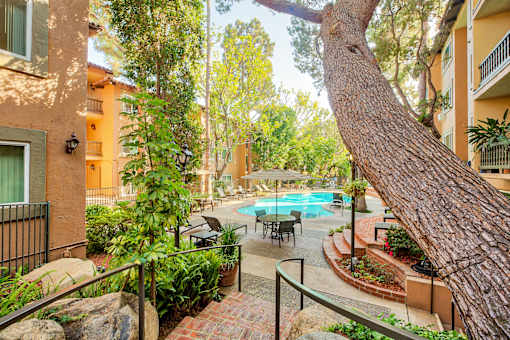 a courtyard with a swimming pool and a tree at Casa Granada, Los Angeles, California