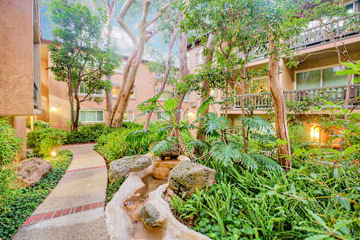 a garden with trees and rocks and a stream at Casa Granada, Los Angeles, 90049