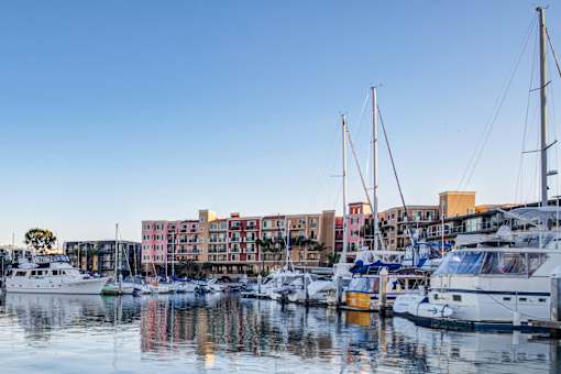 a group of boats docked in a marina with buildings in the background  at Marina Harbor, California, 90292
