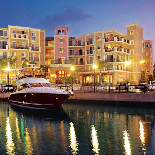 a boat is docked in the water in front of some buildings  at Marina Harbor, Marina del Rey