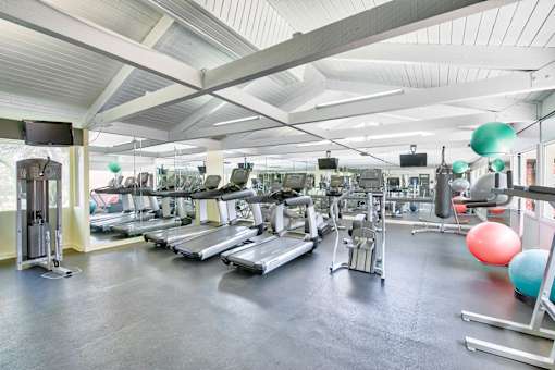a gym with cardio equipment and weights on the floor at Mediterranean Village Costa Mesa, California, 92626