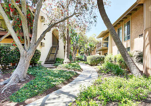 a sidewalk in front of a building with trees at Mediterranean Village Costa Mesa, California, 92626
