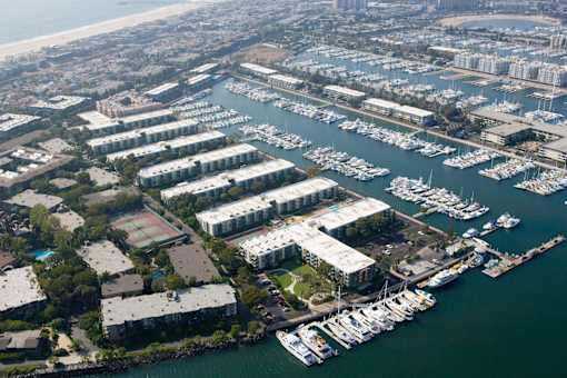 A marina with boats docked in the water and buildings surrounding it.