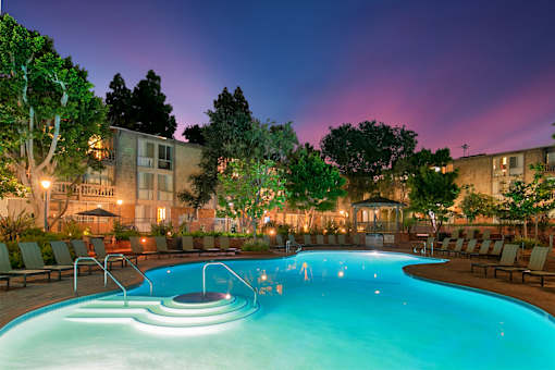 A swimming pool with a few people in it at night at The Meadows Apartments, Culver City , CA 90230
