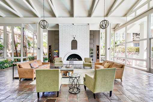 A living room with a fireplace and a white brick wall.