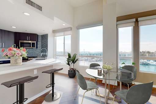 A modern kitchen with a bar area and a dining table set up at Esprit Marina del Rey, 90292