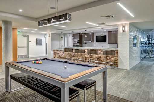 A pool table is in the middle of a room with a bar and a television at Esprit Marina del Rey, 90292