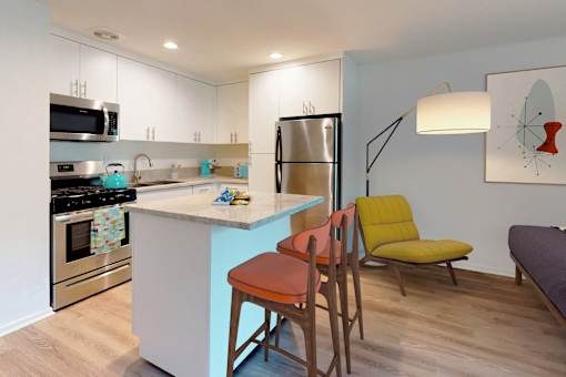 A kitchen with a blue island and a yellow chair at Rancho Los Feliz, Los Angeles, California