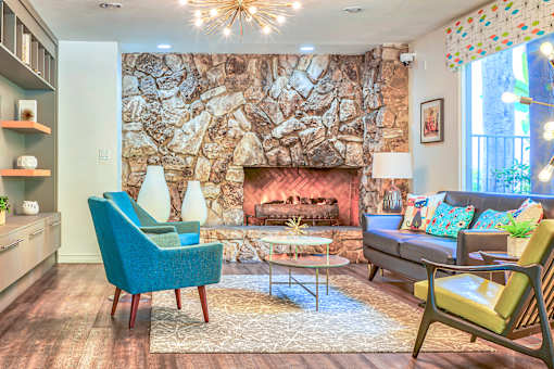 A living room with a stone wall and a fireplace at Rancho Los Feliz, Los Angeles, California